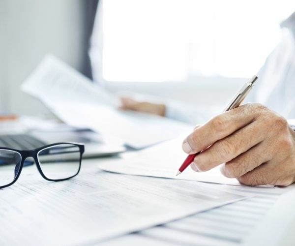 Close-up,Shot,,Businessman,Or,Lawyer,Holding,Pen,Reviewing,Documents,And